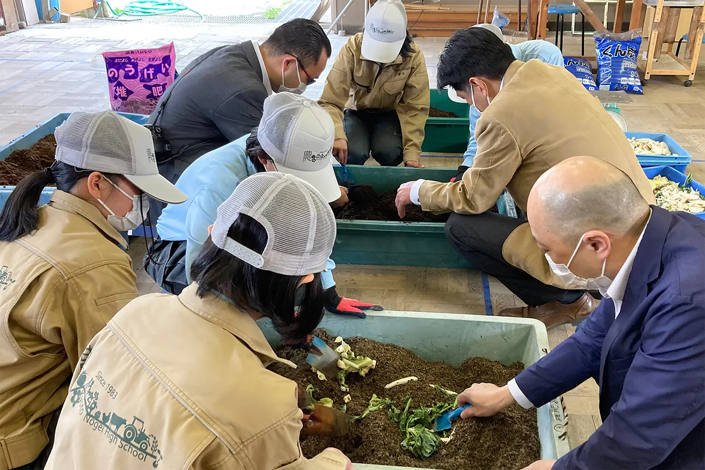 農芸校生から堆肥作りのレクチャーを受けるホテルスタッフ