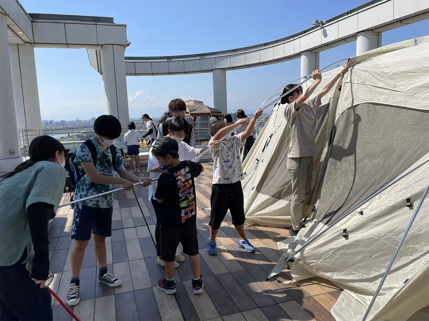 スタッフと一緒にテント張りをする様子